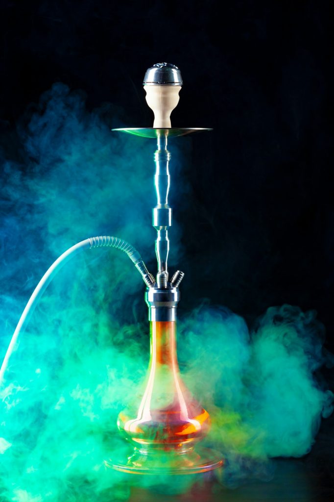 Modern hookah with smoke in dark club light